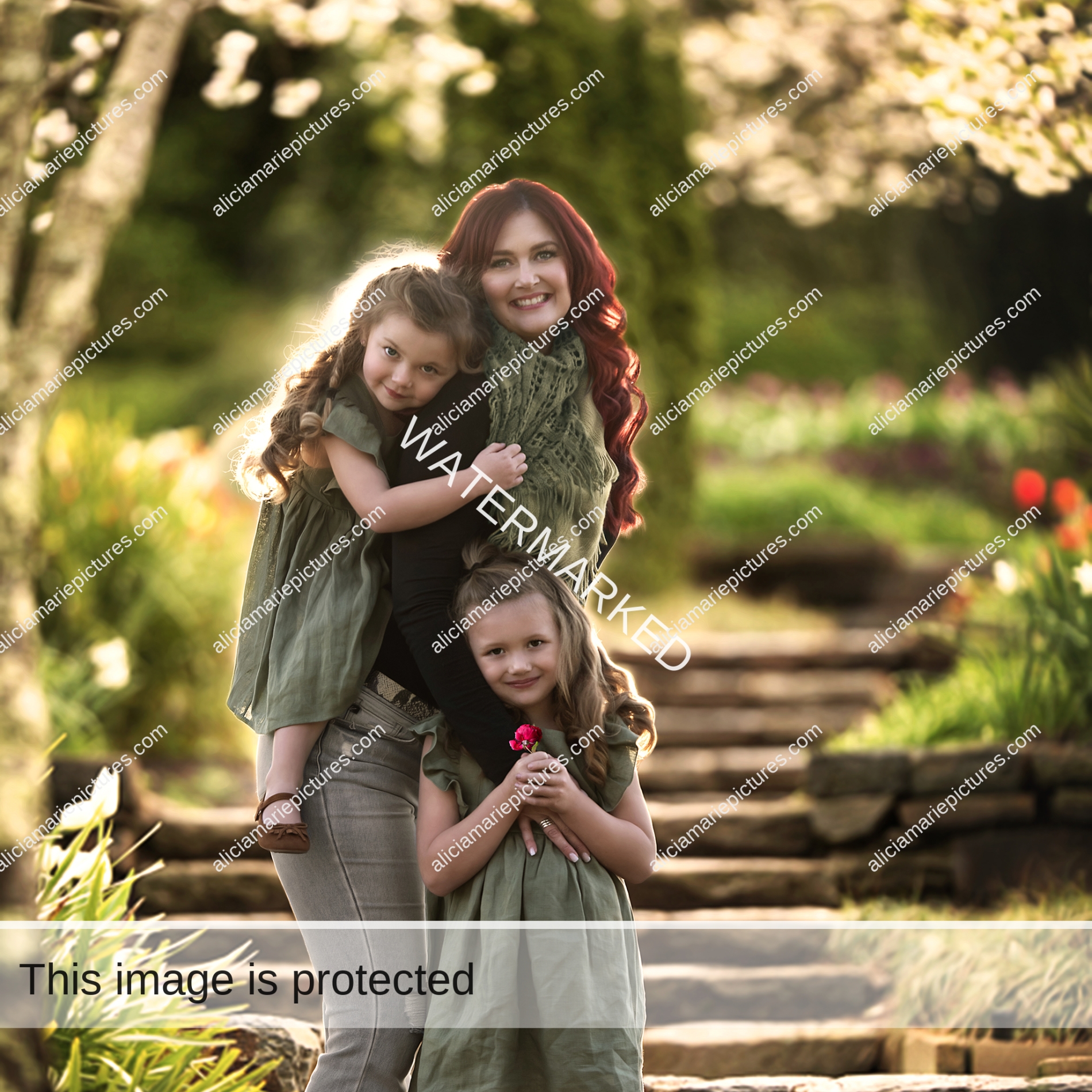 Fine art photography mom with two little girls posing in garden at golden hour