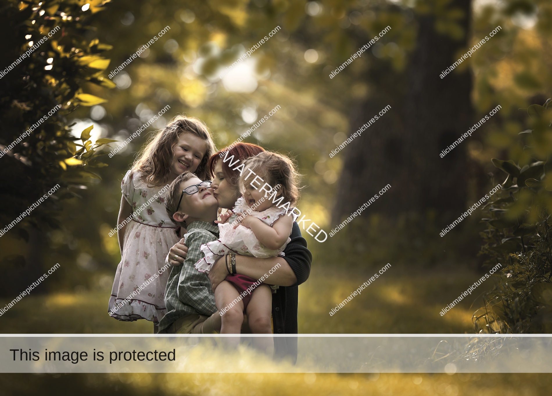 Fine art photography loving mother with three children kissing son during autumn golden hour