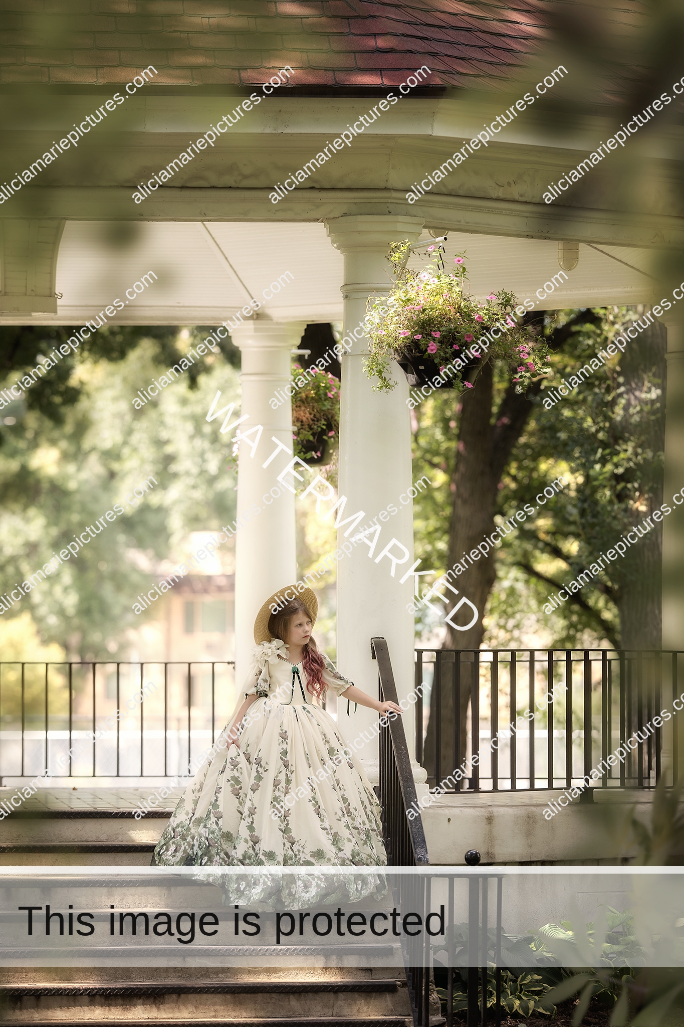 Fine art image of young girl standing in couture gown under gazebo at sunset